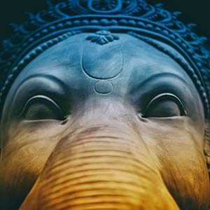 Gesicht einer Ganesha-Statue mit Elefantenrüssel und Krone